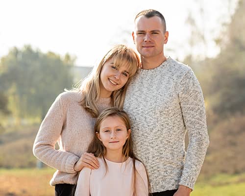 Happy Parents With Daughter Outside Their New Home in Massachusetts